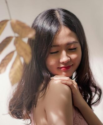 Peaceful young woman with eyes closed, embracing serenity with a gentle smile.