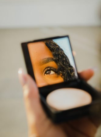 a woman holding a compact compact compact compact compact compact compact compact compact compact compact compact